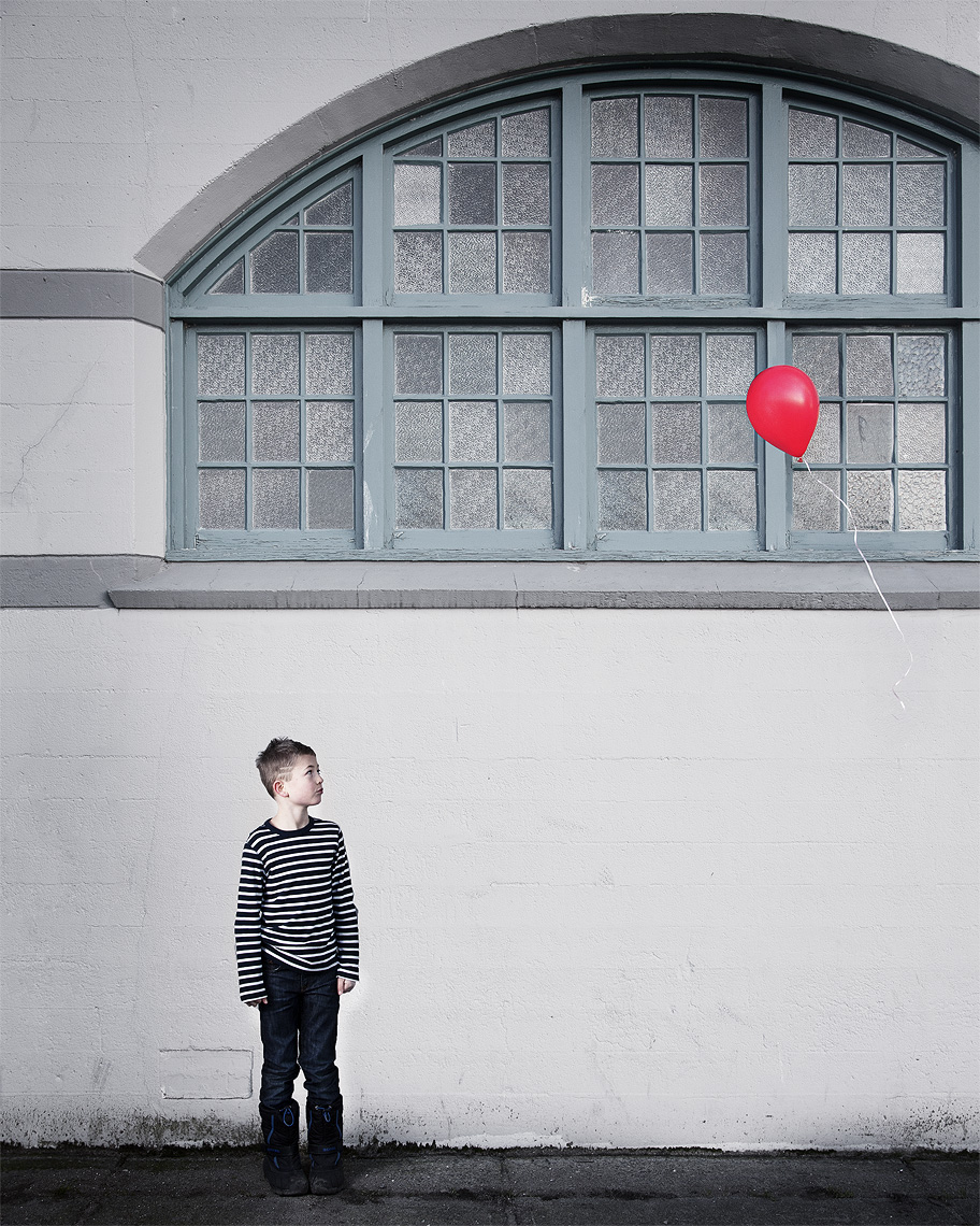 Conceptual Portrait Of A Boy And His Red Balloon